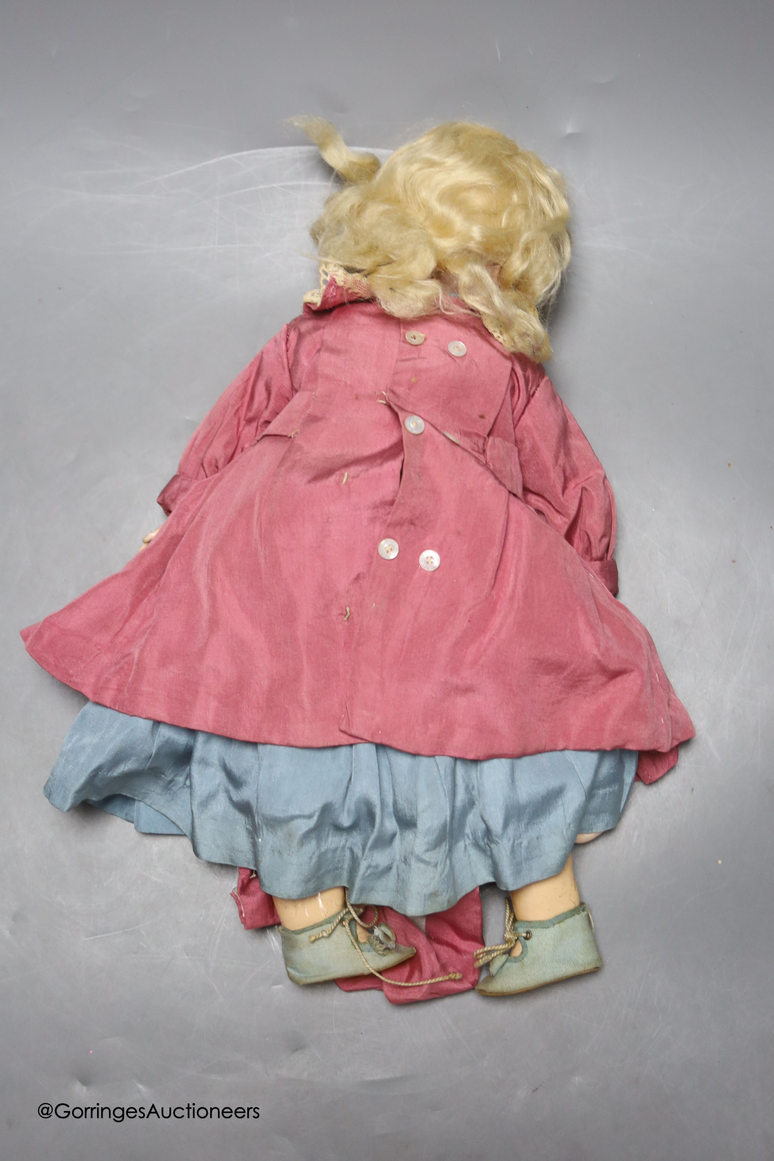 A Kammer and Reinhardt bisque porcelain doll, in original clothes and wig, lower part of left leg detached but present, eyes detached, 33cm tall.